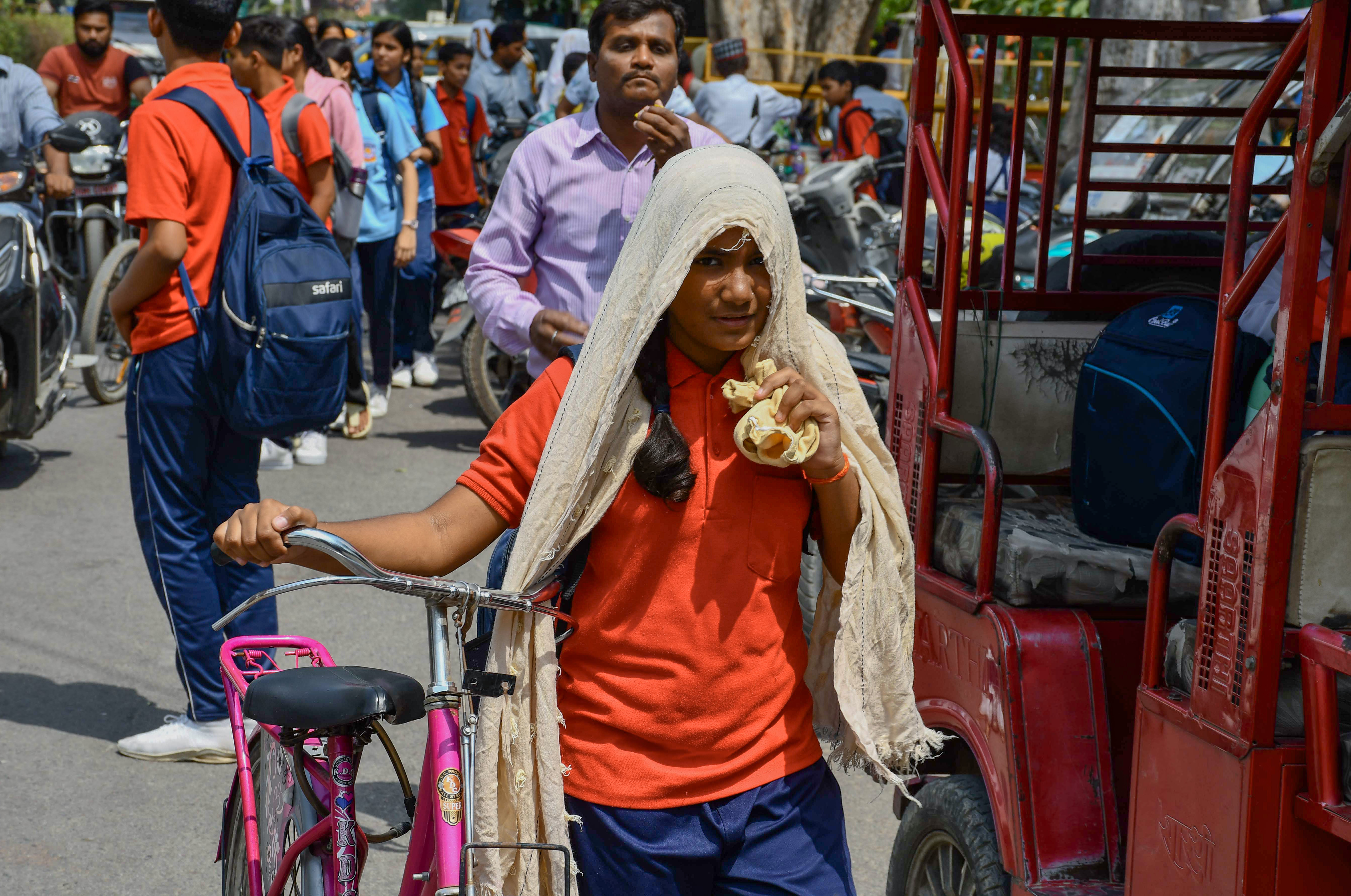 यूपी के प्रयागराज में गर्मी के चलते स्कूल से लौट रही स्टूडेंट ने स्कॉर्फ से सिर ढंका।