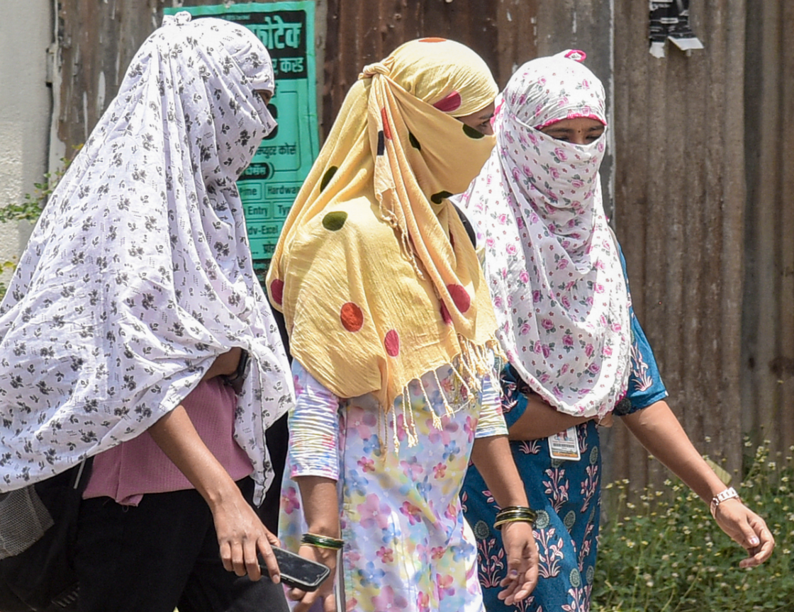महाराष्ट्र के कराड में भीषण गर्मी से बचने के लिए युवतियां स्कार्फ का सहारा ले रही हैं।