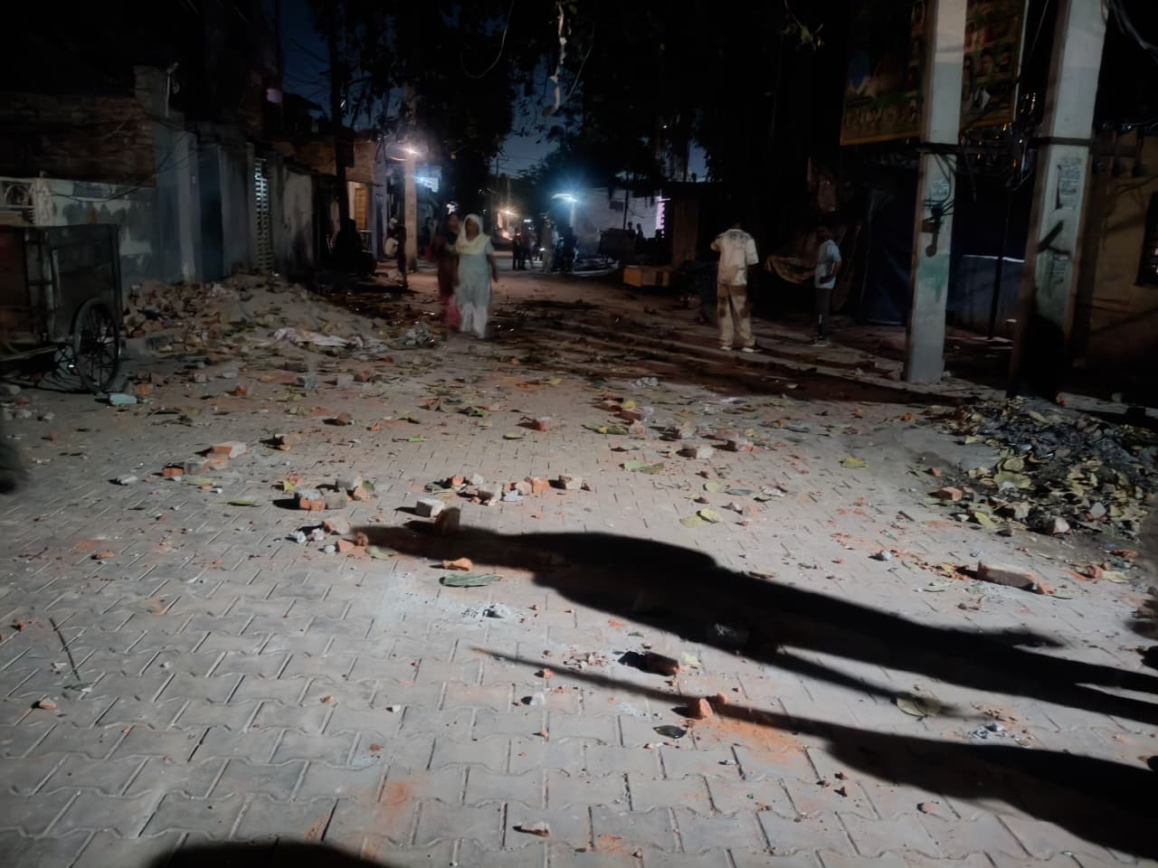 गली में ईंट-पत्थर गिरे हुए।
