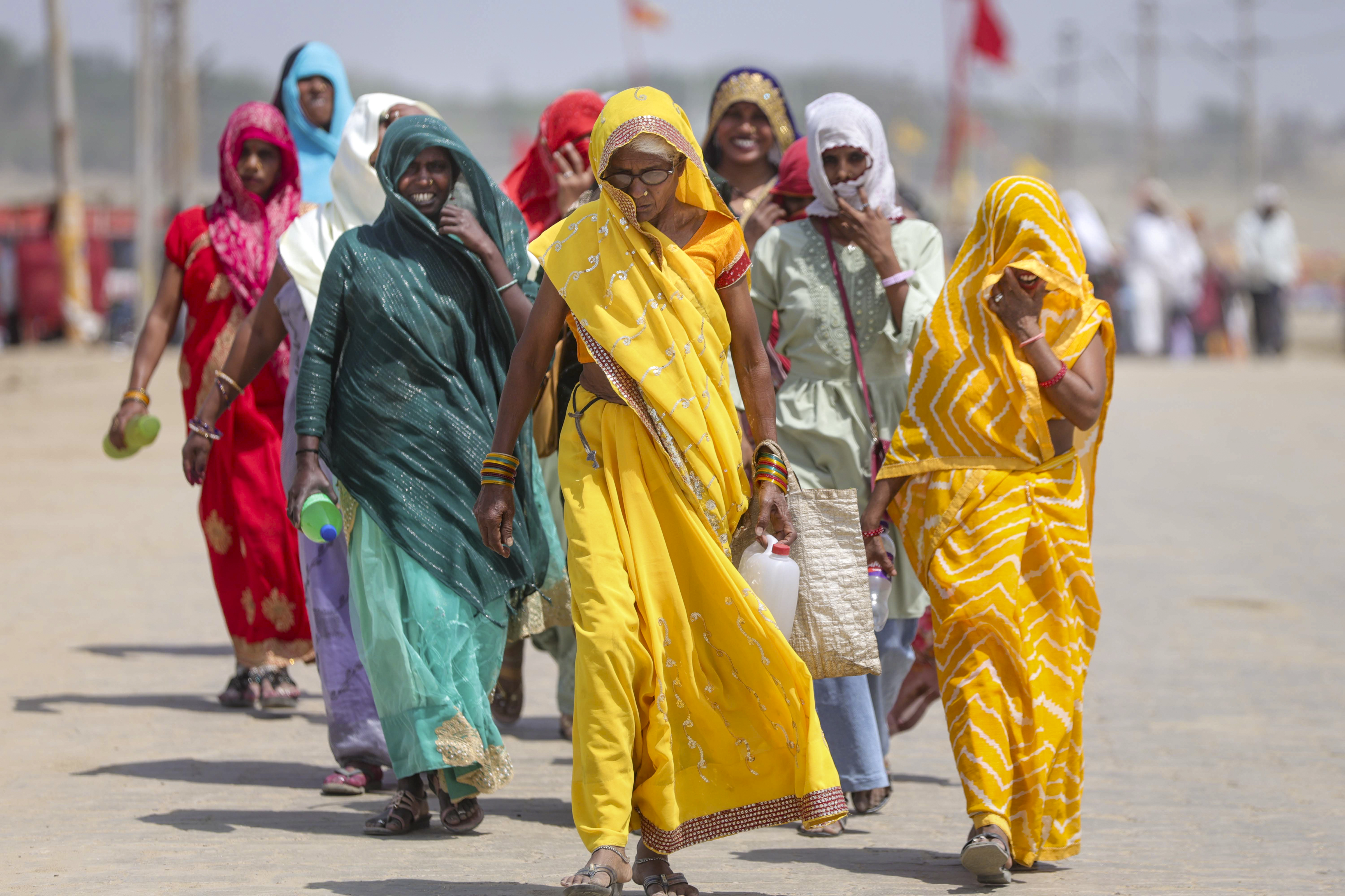 यूपी के प्रयागराज में तेज धूप में जाती महिलाएं।