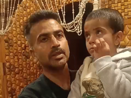 पिता गोपाल की गोद में बच्चा।