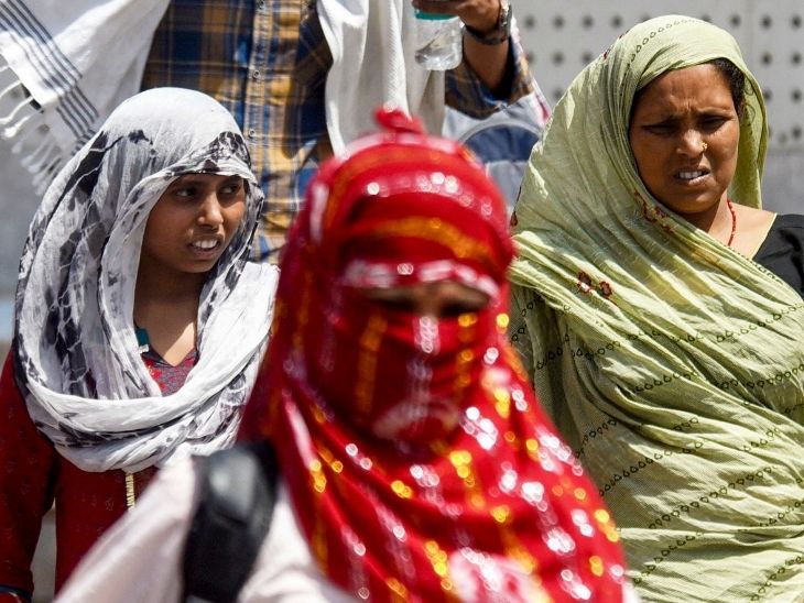 बिहार के पटना में तेज धूप से बचने के लिए फेस कवर करके जाती महिलाएं।