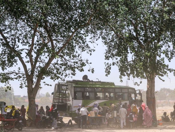 यूपी के प्रयागराज में तेज गर्मी के बीच बस स्टॉप पर इंतजार करते यात्री।