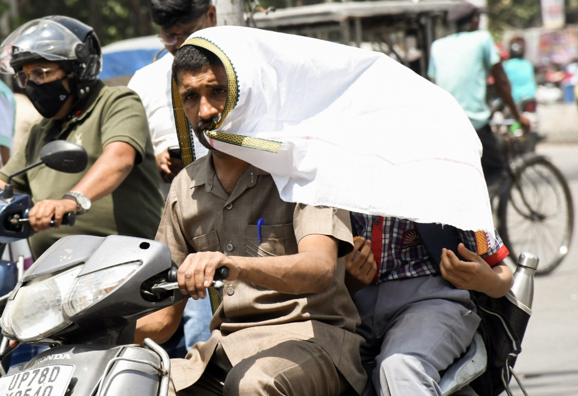 कानपुर में बच्चे को स्कूल से लेकर लौटते वक्त गमछे से ढांककर ला रहे हैं। यहां सोमवार को पारा 42.6 डिग्री रहा।