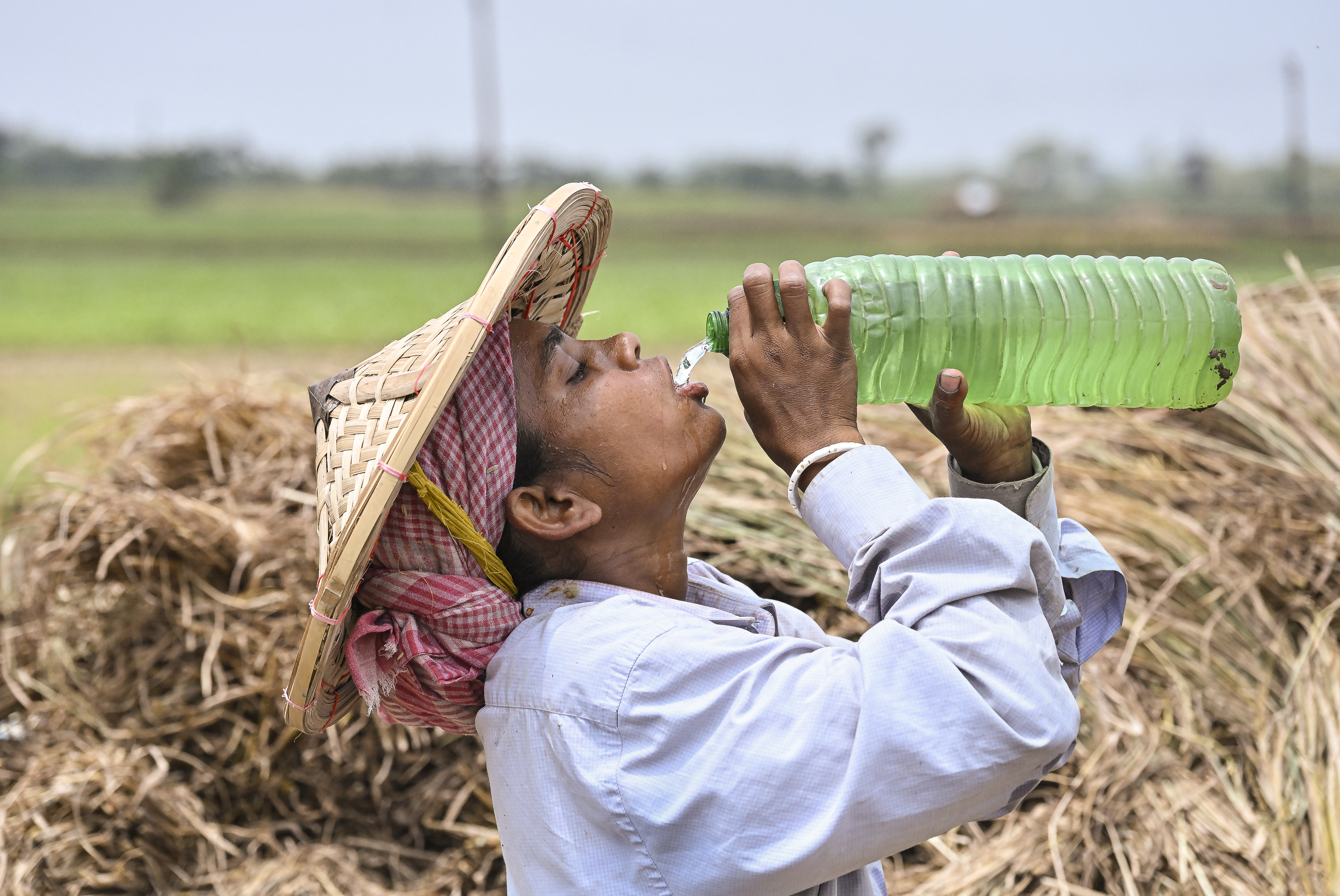 पश्चिम बंगाल के नादिया में पानी पीती महिला।
