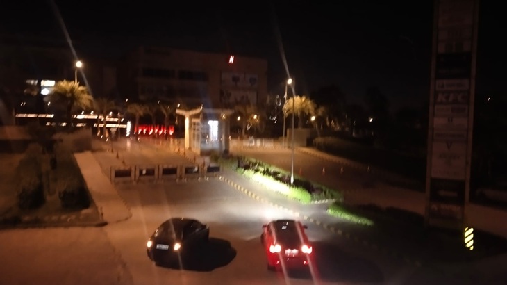 सोमवार रात को मॉल गेट से वापस जाते कार सवार लोग।