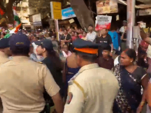 पुरुष पुलिसकर्मी महिला पुलिसकर्मियों को महिला को हटाने के लिए कहता है।