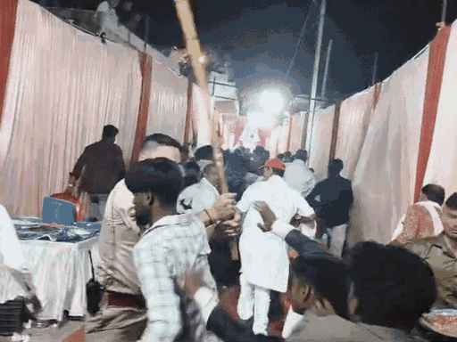 चश्मा पहने पुलिसकर्मी लोगों को डंडे से मारता दिख रहा है।