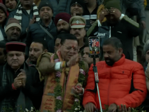 बद्रीनाथचे दर्शन घेऊन बाहेर आलेले मुख्यमंत्री धामी भाविकांवर फुले उधळताना.