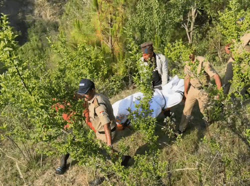 खाई से शव को निकालकर सड़क की तरफ लाती पुलिस की टीम।