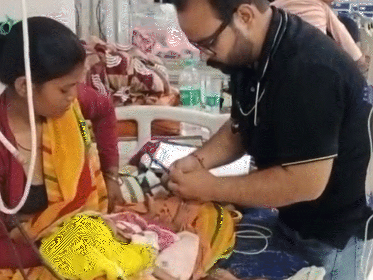 कुपोषित बच्चे का इलाज कराती उसकी मां।