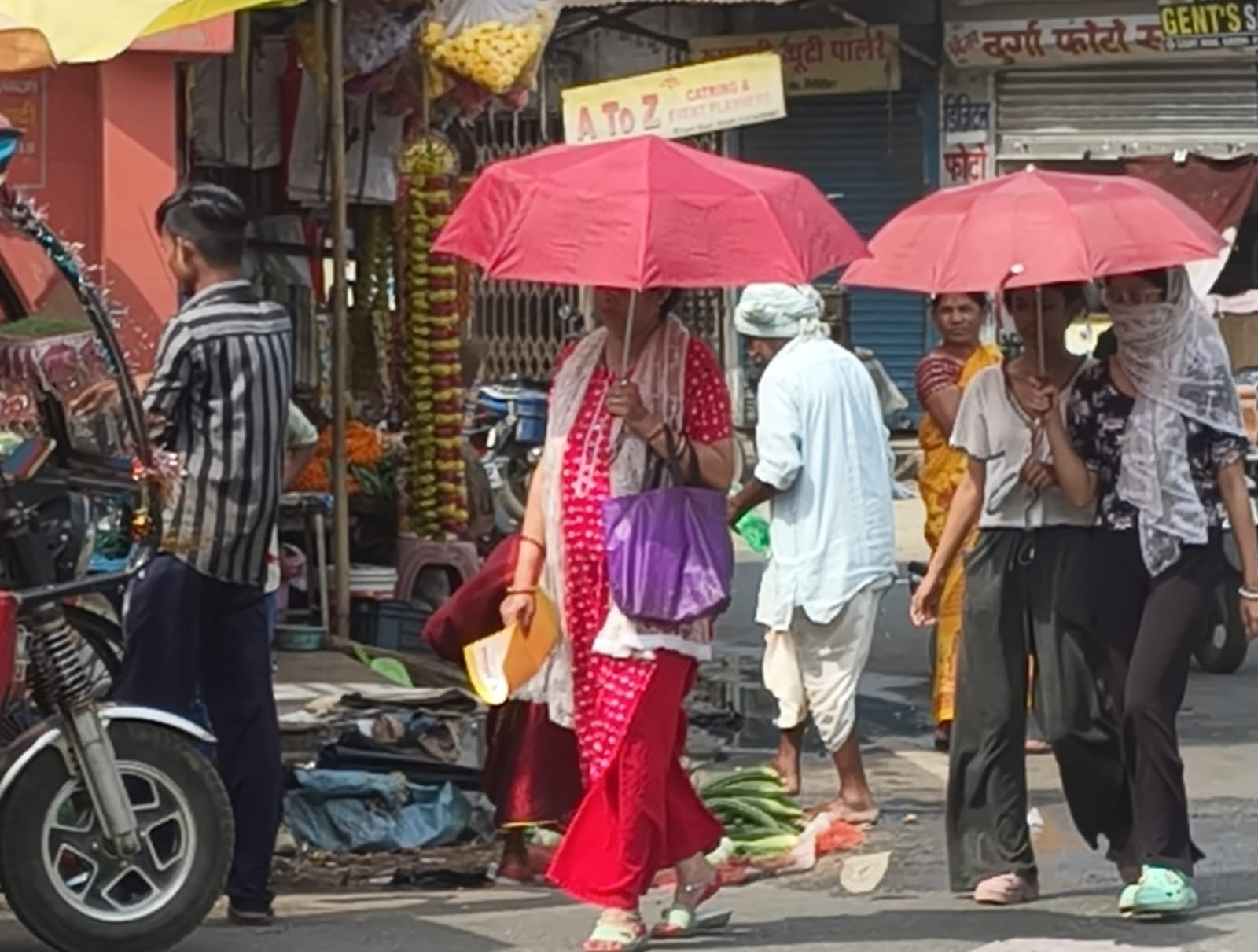 गिरिडीह में गुरुवार को सड़क पर निकलने के लिए धूप से बचने के लिए लोग छाता का सहारा लेते दिखे।