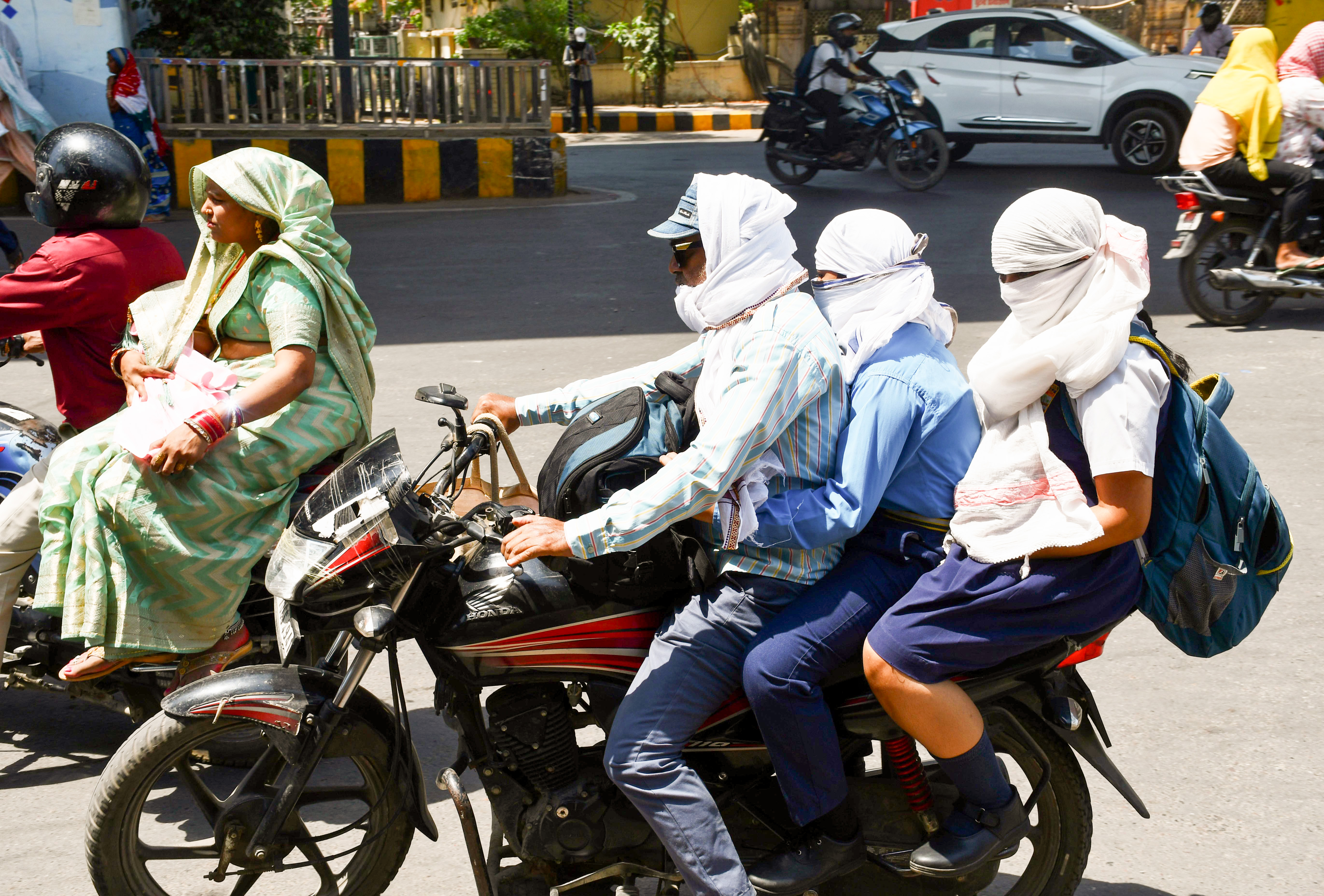 प्रयागराज में भीषण गर्मी के बीच लोग चेहरा ढककर सफर करते नजर आए।