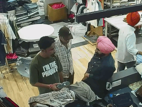 नौसरबाज दुकान पर कपड़ों की खरीददारी करता हुआ।