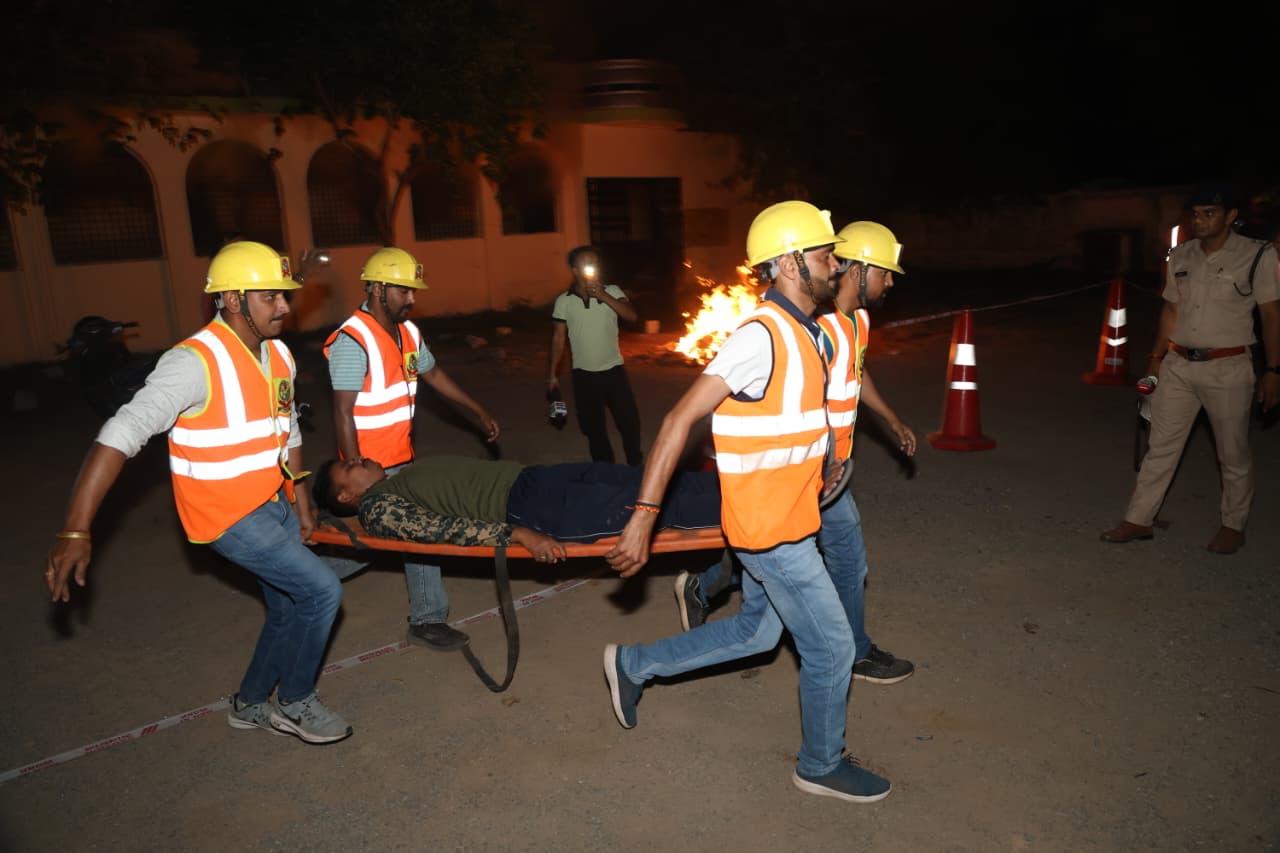 बिल्डिंग में हमले के दौरान घायल व्यक्ति को स्ट्रेचर पर ले जाते हुए SDERF के कर्मचारी।