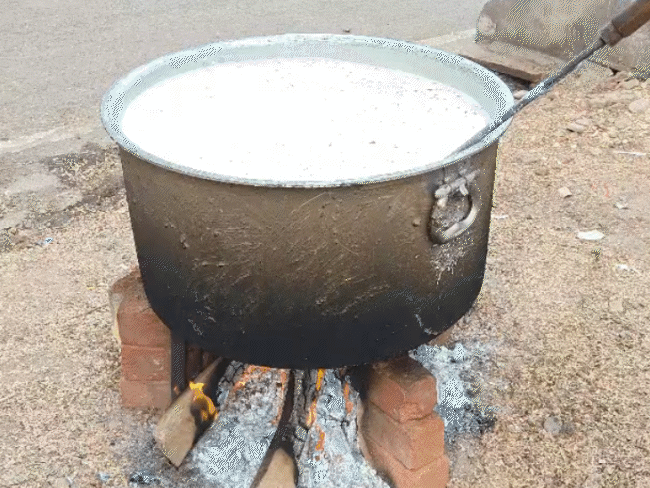 सिलेंडर की किल्लत के चलते लोग लकड़ी की बड़ी भटि्टयों पर खाना बनवा रहे हैं।