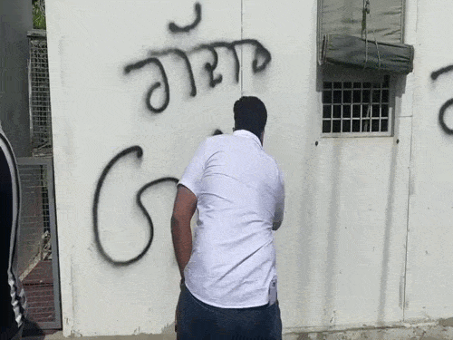 भज्जी के घर के बाहर दीवार पर 'गद्दार' लिखता आम आदमी पार्टी का कार्यकर्ता। - Dainik Bhaskar