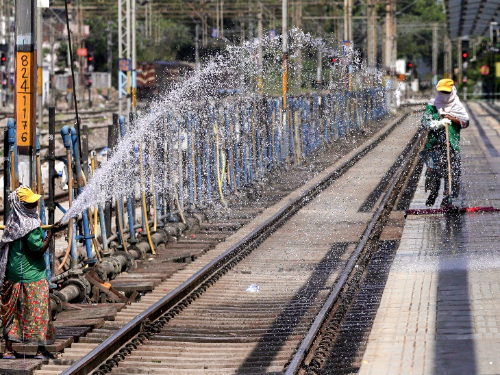 उत्तर प्रदेश के प्रयागराज जंक्शन पर शुक्रवार को भीषण गर्मी के बीच एक रेलवे कर्मचारी प्लेटफॉर्म पर पानी छिड़क रहा है। यहां पारा 45°C पार हो गया है।