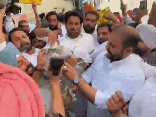 पोस्टरों पर जूते मारते आप नेता।