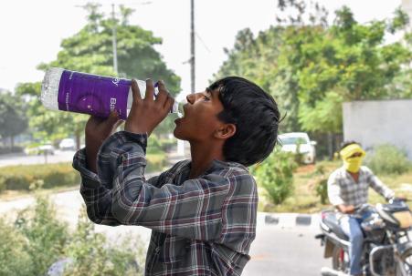 गाजियाबाद में भीषण गर्मी के दौरान पानी पीता एक बच्चा।