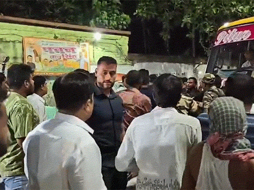 झड़प के दौरान चेहरे पर गमछा बांधकर पत्थर फेंकता एक व्यक्ति।