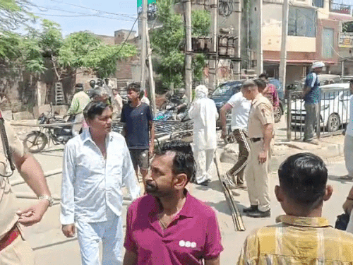 सड़क पर बल्लियां लगाते लोग व पहुंची पुलिस।
