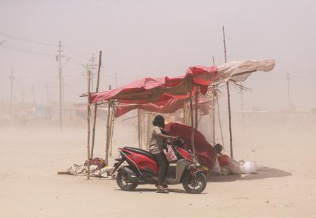 प्रयागराज में तपती गर्मी के बीच धूलभरी आंधी भी चली। गंगा किनारे इसी आंधी से बचाव करता एक शख्स।