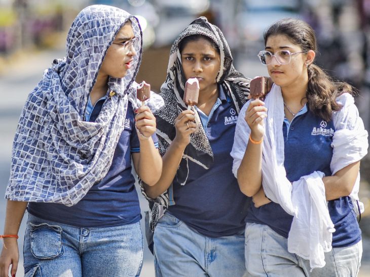 नागपुर में स्कार्फ से सिर ढकी लड़कियां आइसक्रीम खाते हुए गर्मी से राहत लेती दिखीं।