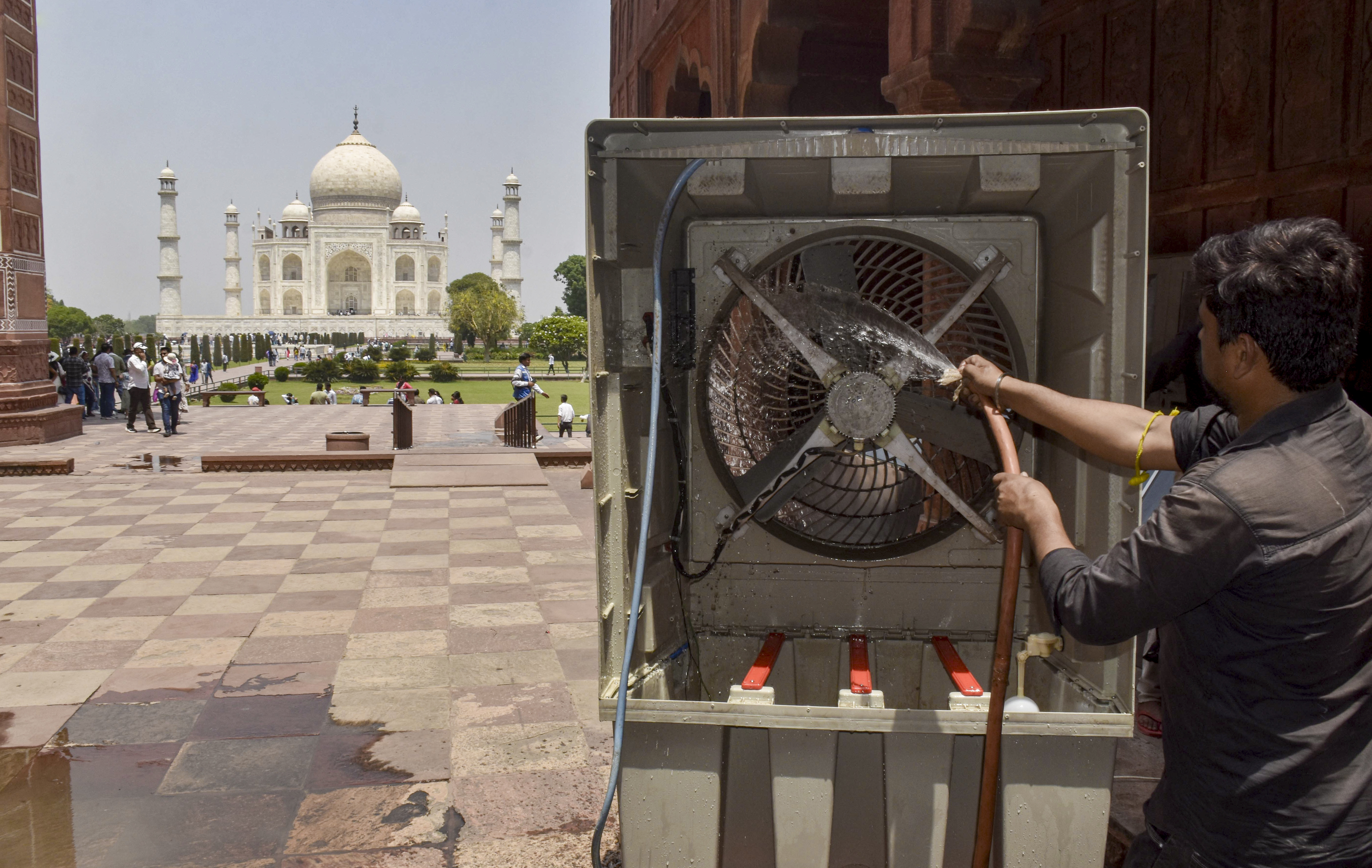 आगरा में 43.9°C पारा होने के बाद ताज महल के पास एक कर्मचारी कूलर साफ करता नजर आया।