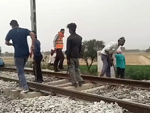 सोमवार रात हुए ब्लास्ट के बाद पटरी की मरम्मत करने पहुंचे रेलवे के कर्मचारी।