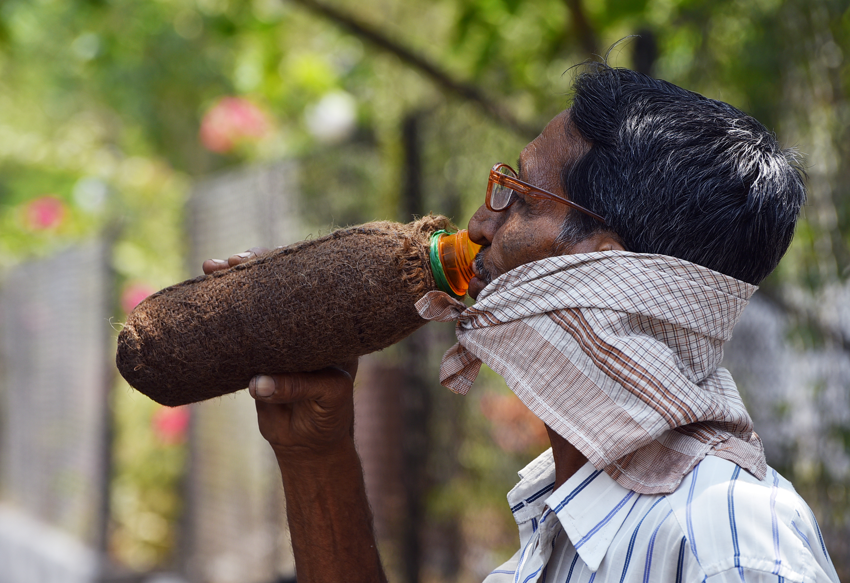 महाराष्ट्र के अकोला में तपती गर्मी के बीच प्यास बुझाता शख्स। पानी ठंडा रहे, इसलिए बोतल को भी ढंक लिया है।