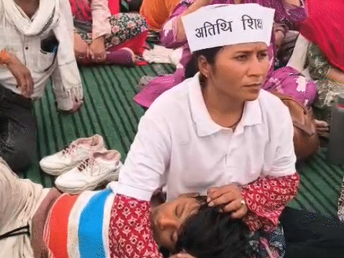 महिला शिक्षक बच्चे के साथ प्रदर्शन में पहुंची हैं।