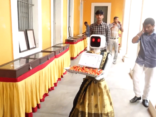 पुडुचेरी में मतदान केंद्र पर रोबोट ने मतदाताओं का फूलों से स्वागत किया।