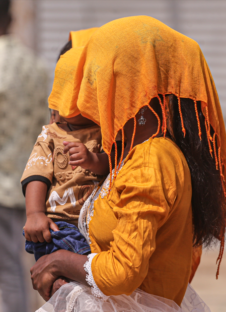 प्रयागराज में एक मां ने खुद और बच्चे को तपिश से बचाने के लिए मुंह को दुपट्टे से ढंक लिया।