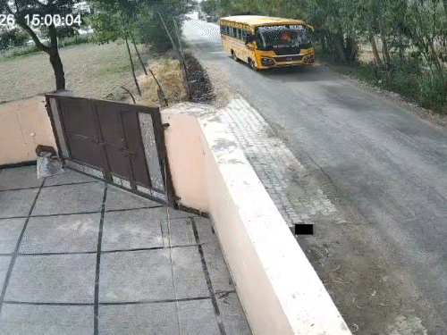 बच्चे को उतारने के लिए घर के सामने रुकी स्कूल बस।