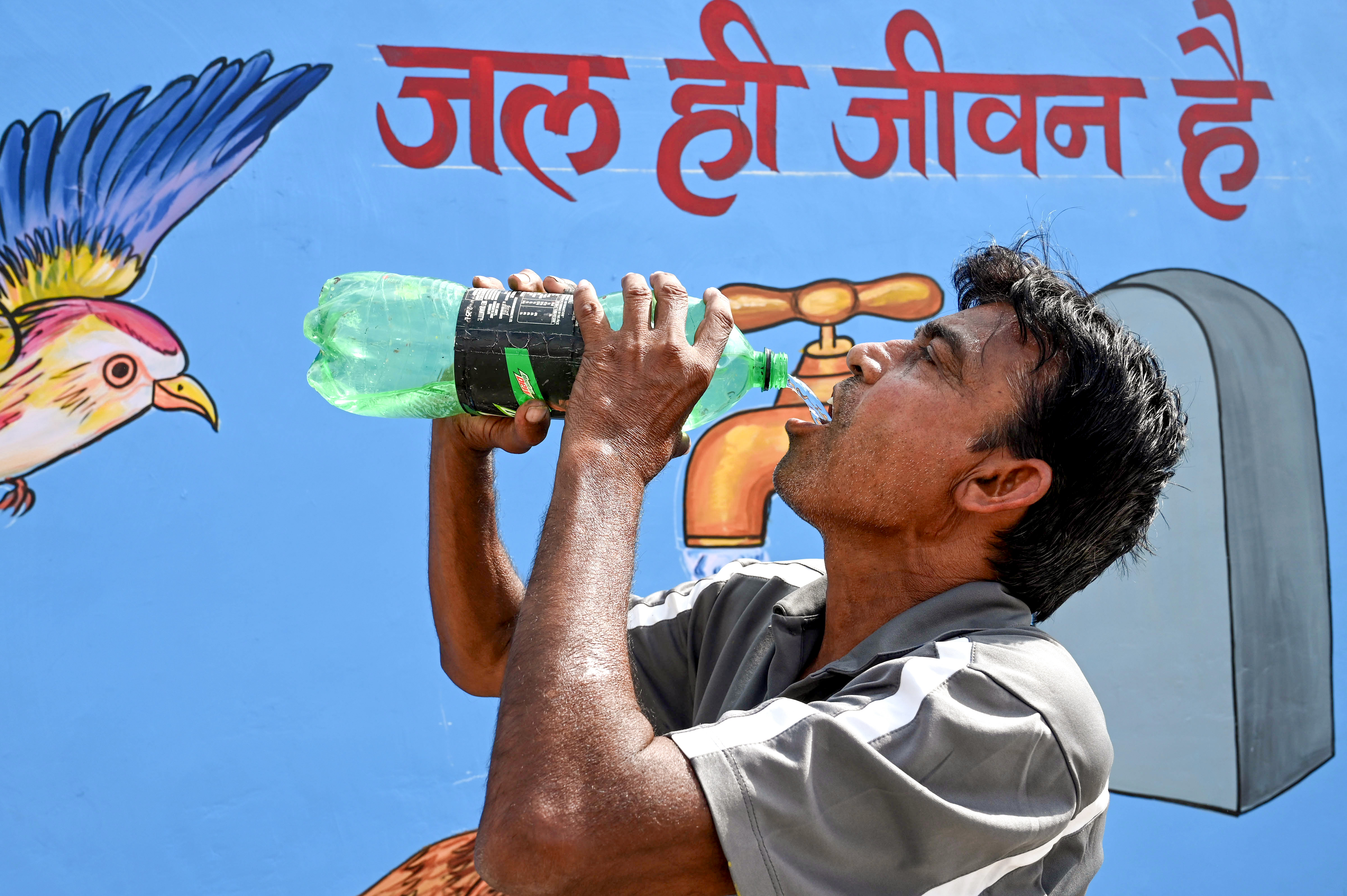 राजस्थान के बीकानेर में गुरुवार को चिलचिलाती गर्मी से बचने के लिए पानी पीकर राहत पाने की कोशिश करता व्यक्ति।
