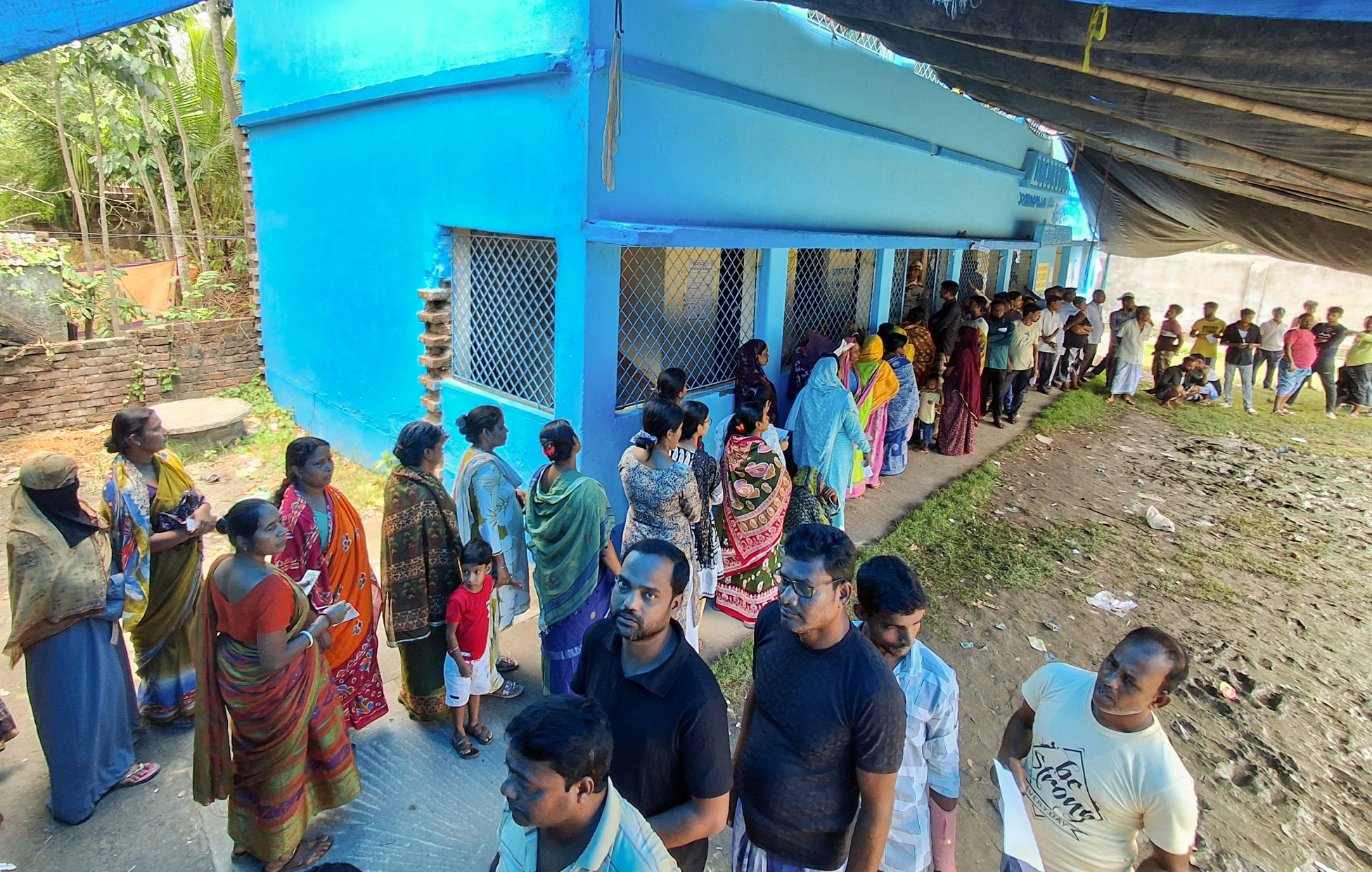 मगराहाट पश्चिम के बूथ पर वोट डालने के लिए लाइन में खड़े वोटर।