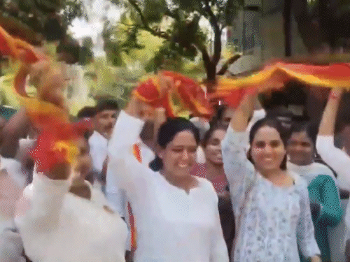 कोयंबटूर में पार्टी कार्यकर्ताओं ने TVK के प्रतीक लाल-पीले गमछे लहराकर जश्न मनाया।