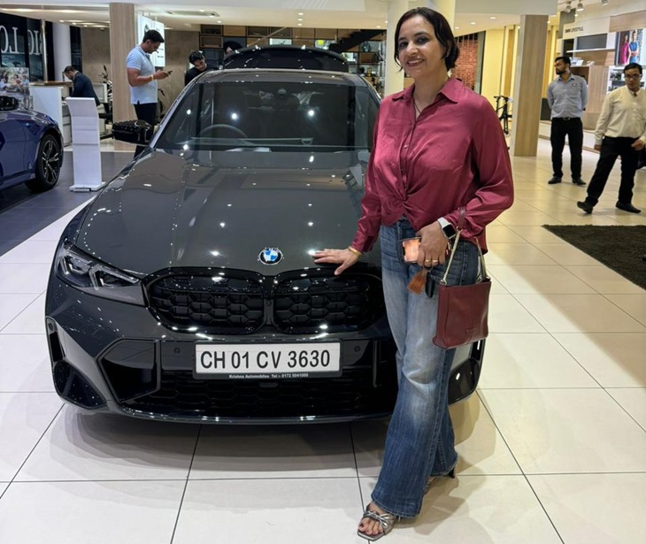 शोरूम में BMW कार के साथ फोटो खिंचवाती अमरीन राय।