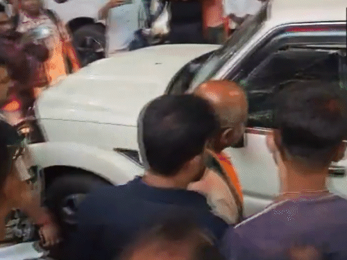 रथ की कार को देखते बीजेपी कार्यकर्ता और अन्य लोग।