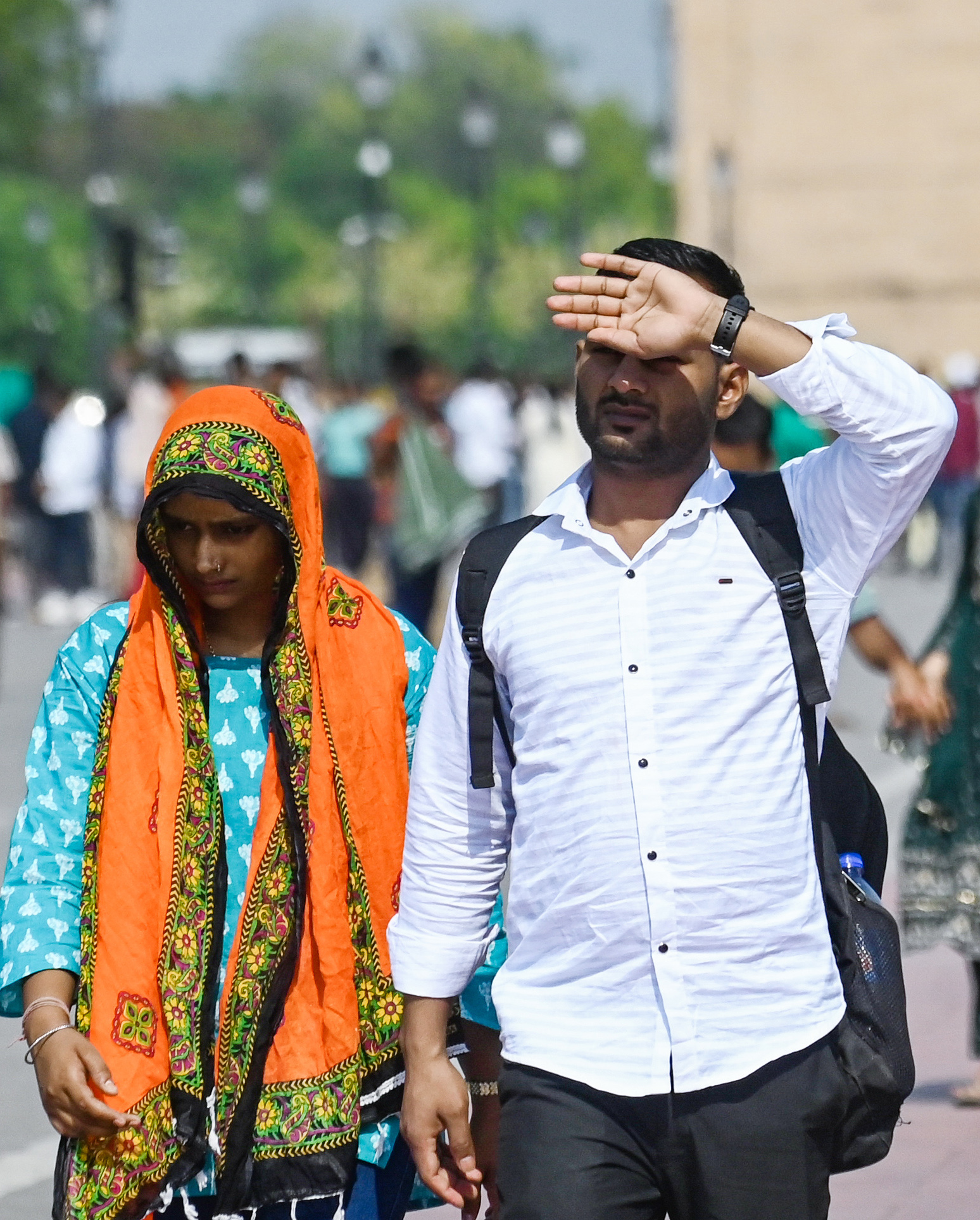 नई दिल्ली में इंडिया गेट पर चिलचिलाती गर्मी से खुद को बचाने की कोशिश करते दिखे।