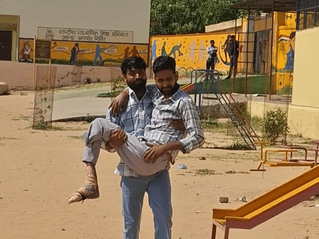दिव्यांग को गोदी में उठाकर सेंटर पर लेकर जाते हुए।