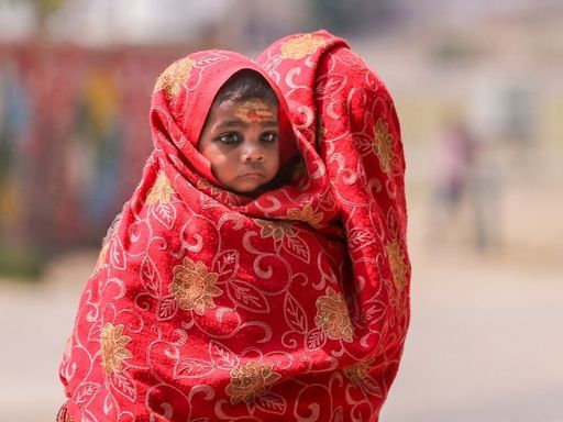 प्रयागराज में धूप और गर्मी से बचाने के लिए महिला ने अपने बच्चे को कपड़े से ढंका। यहां अधिकतम तापमान 39.4°C के पार पहुंच गया है।