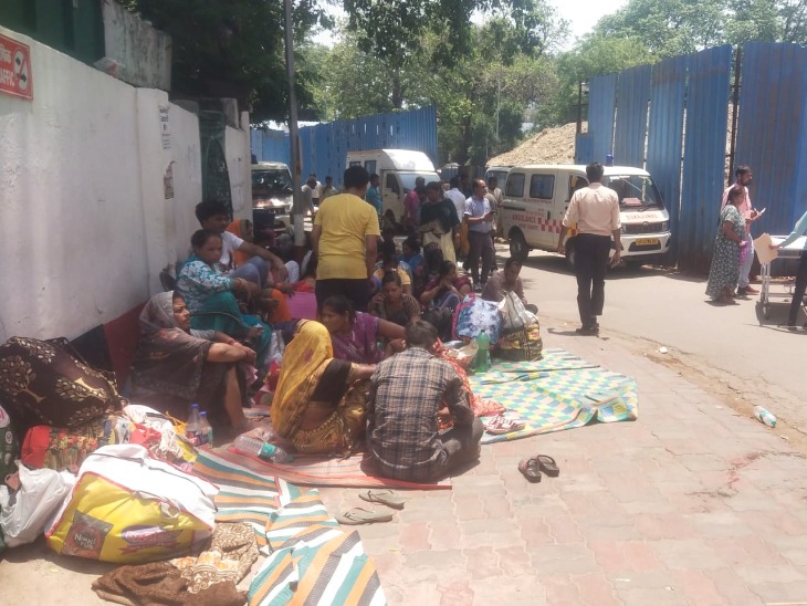 तेज धूप में ट्रॉमा सेंटर के बाहर बैठे मरीज और तीमारदार।