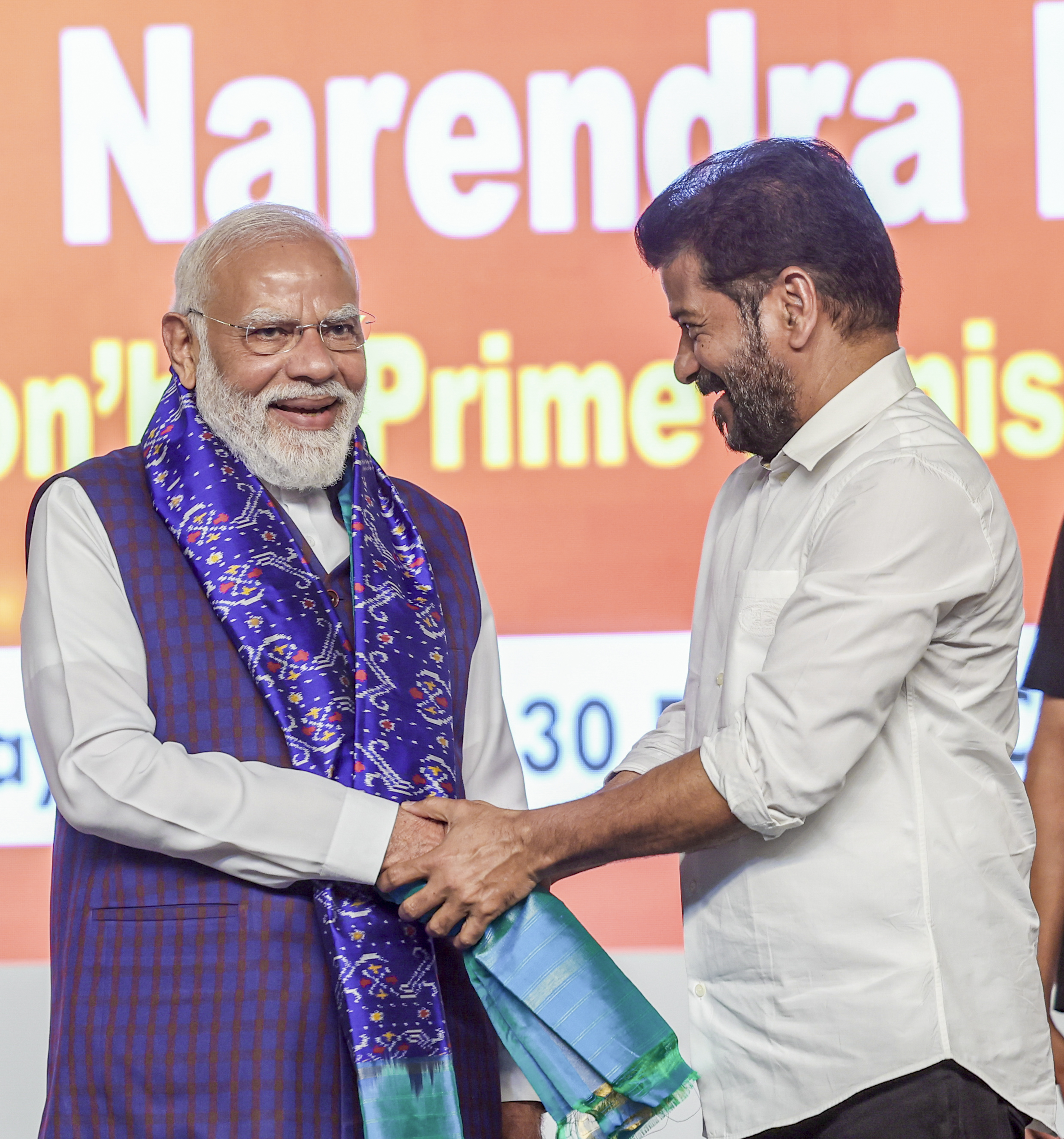 हैदराबाद में डेवलेपमेंट प्रोजेक्ट्स के इनॉगरेशन के दौरान रेवंत रेड्डी पीएम मोदी स हाथ मिलाते हुए।