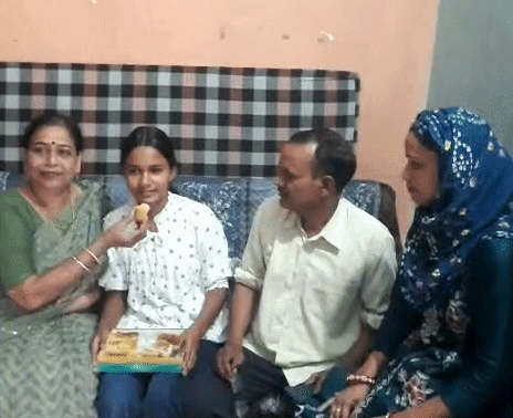 दीपिका को मिठाई खिलातीं उप प्राचार्या एवं हिंदी शिक्षिका प्रोमिला यादव और साथ में उसके माता-पिता।