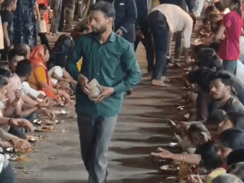 मंदिर में पंगत प्रसादी लेते भक्त।
