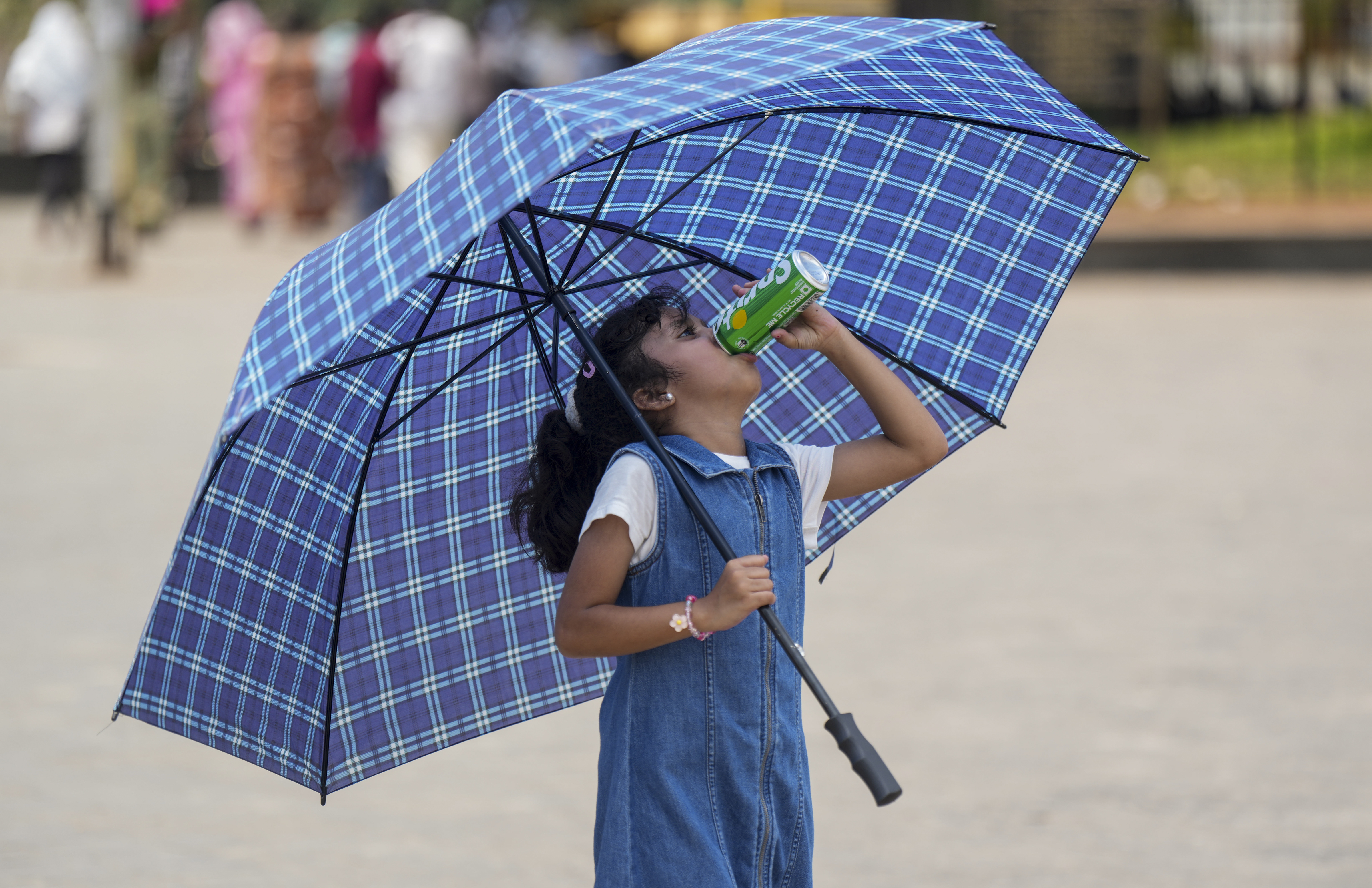 महाराष्ट्र के मुंबई में गर्मी से बचने के लिए बच्चे भी छाता लगाकर निकल रहे हैं।