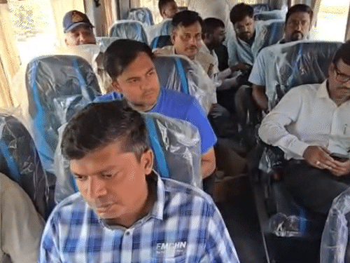 ट्रैवलर बस से निरीक्षण के लिए जाते हुए अधिकारी।