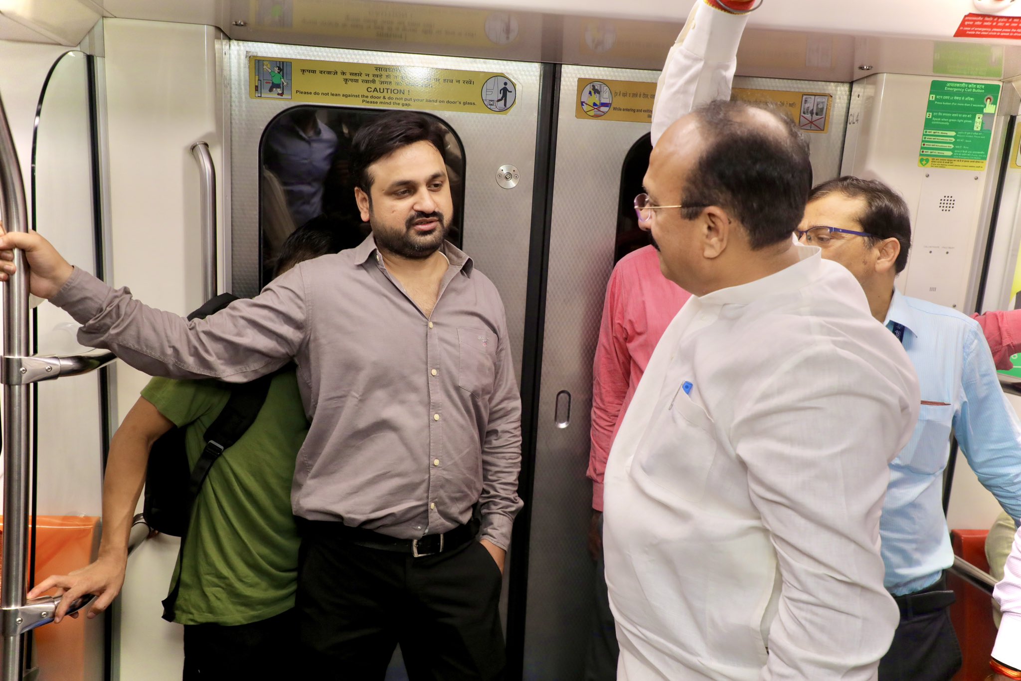 मेट्रोमध्ये प्रवास करताना दिल्ली सरकारमधील मंत्री आशिष सूद (कुर्ता-पायजामा परिधान केलेले).